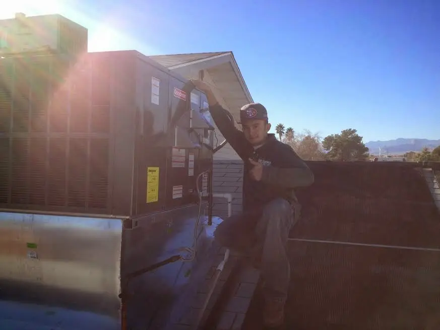 HVAC technician performing Boiler Repair on a rooftop unit in Conneaut